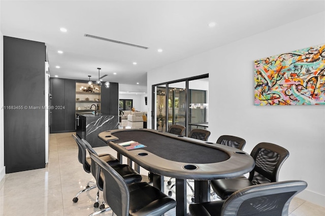 game room with a notable chandelier, sink, and light tile patterned floors