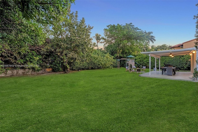 view of yard featuring a playground and a patio area