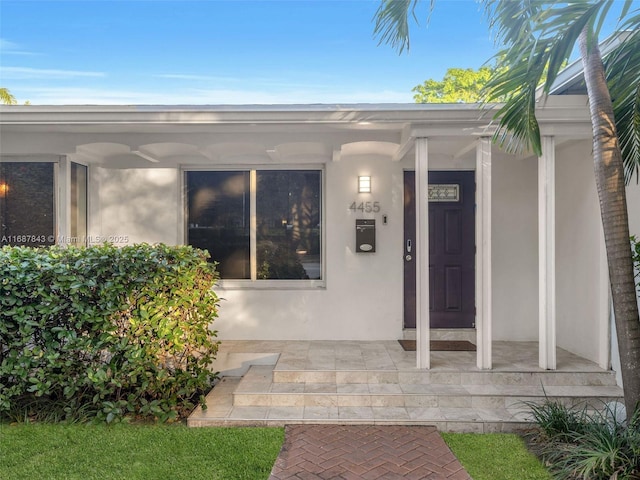 view of exterior entry with stucco siding