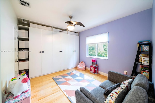 playroom with a ceiling fan, baseboards, visible vents, and wood finished floors