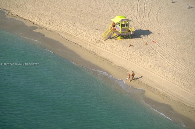 drone / aerial view featuring a water view and a view of the beach