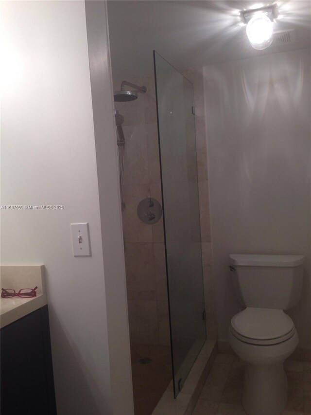 bathroom with a shower with door and toilet