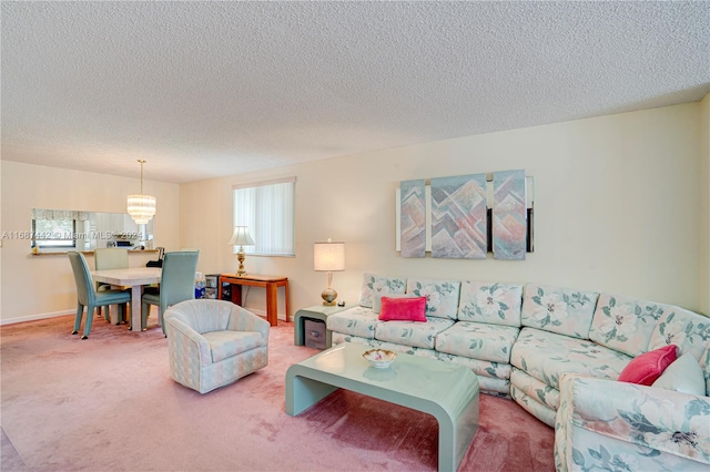 living room featuring carpet, a notable chandelier, and a textured ceiling