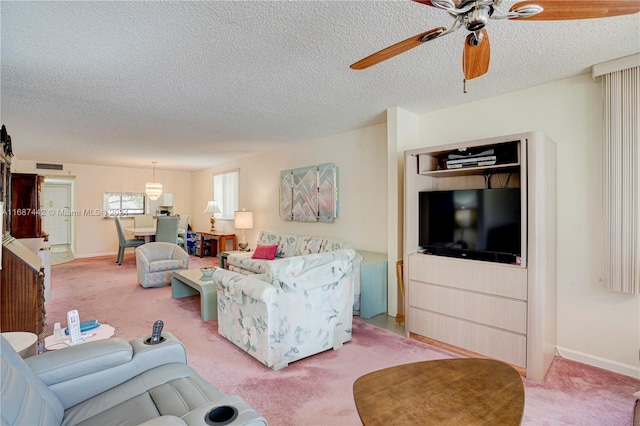 living room with a textured ceiling, light carpet, and ceiling fan