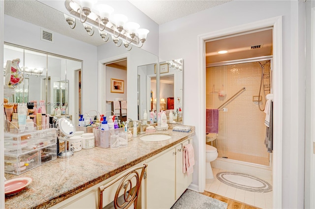 full bathroom with tile patterned floors, toilet, bath / shower combo with glass door, a textured ceiling, and vanity