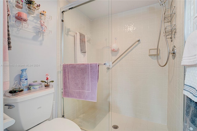 bathroom with toilet and a shower with shower door