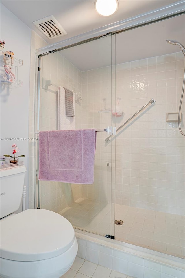 bathroom with walk in shower, tile patterned floors, and toilet