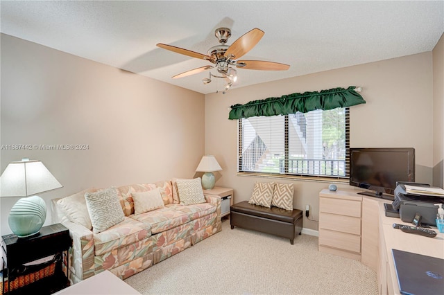 carpeted living room featuring ceiling fan and a textured ceiling