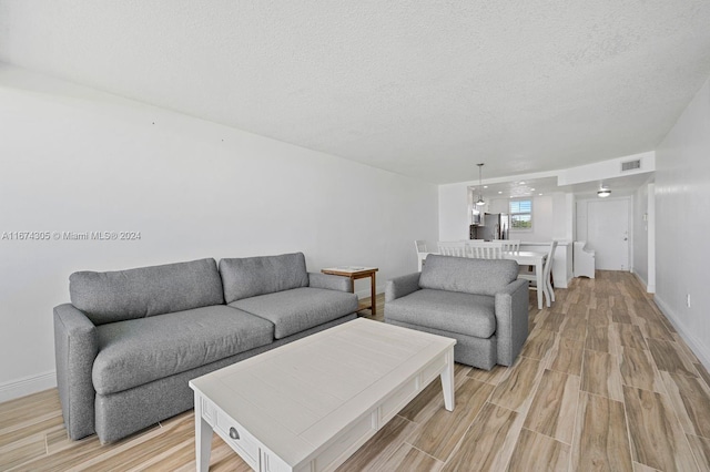 living room featuring a textured ceiling and light hardwood / wood-style flooring