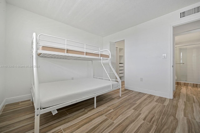 unfurnished bedroom featuring hardwood / wood-style flooring, a closet, and a walk in closet