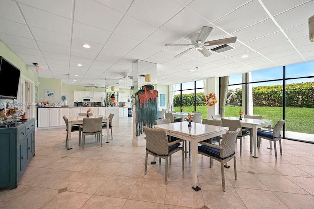 dining area with expansive windows, a paneled ceiling, ceiling fan, and light tile patterned floors