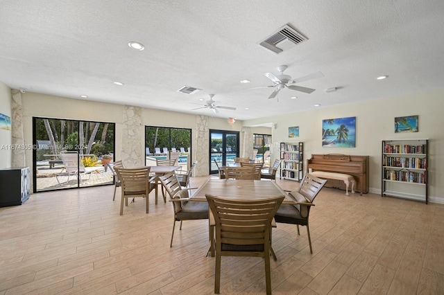 dining room featuring a textured ceiling, ceiling fan, and light hardwood / wood-style flooring