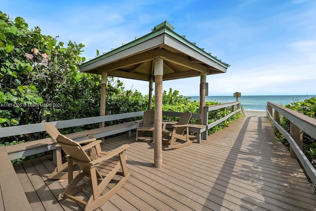 deck with a beach view and a water view