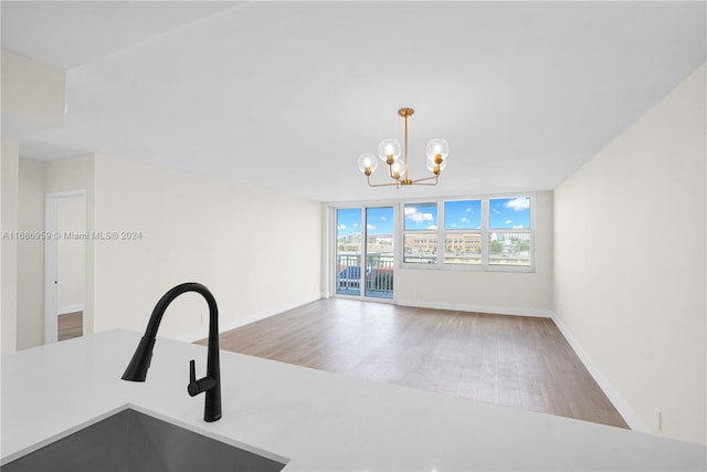 kitchen featuring hanging light fixtures, sink, hardwood / wood-style floors, a notable chandelier, and floor to ceiling windows