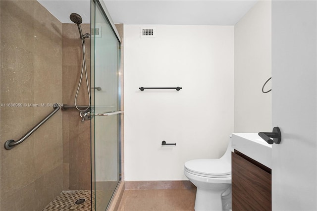 bathroom featuring vanity, tile patterned flooring, toilet, and walk in shower