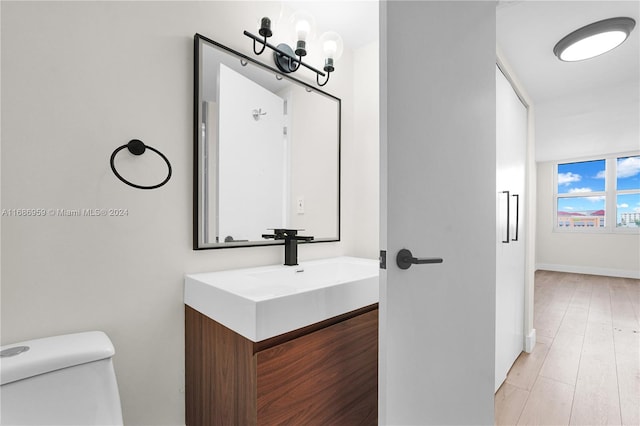 bathroom with vanity, a chandelier, wood-type flooring, and toilet