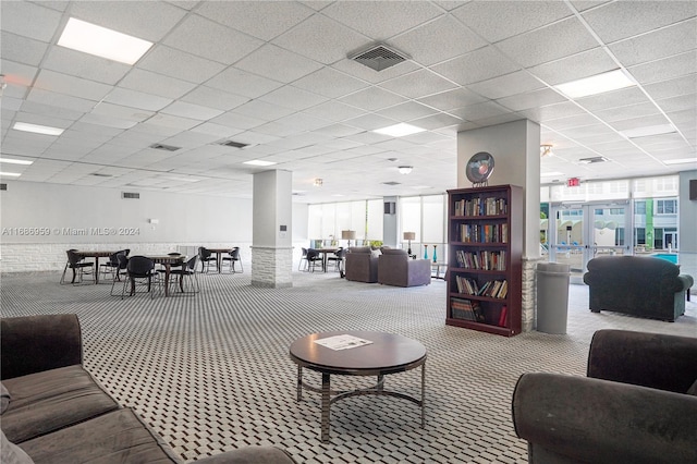 carpeted living room with a drop ceiling and french doors