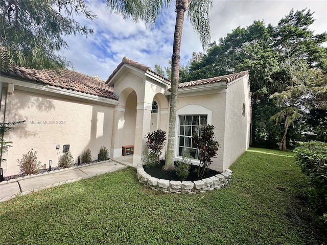 mediterranean / spanish-style home featuring a front yard