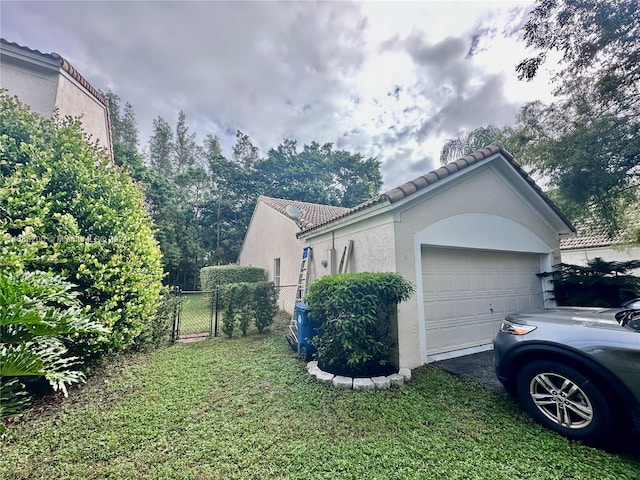 view of property exterior featuring a garage and a lawn