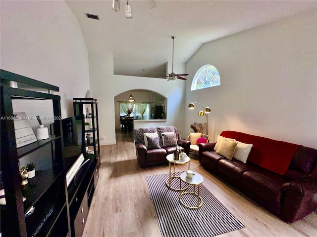 living room featuring hardwood / wood-style floors, high vaulted ceiling, and ceiling fan