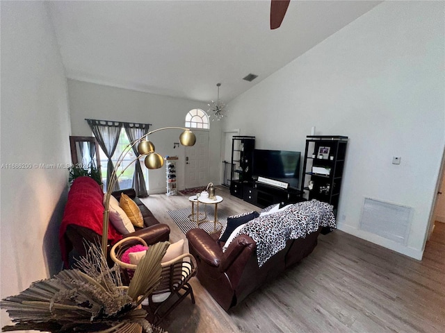 living room featuring ceiling fan, wood-type flooring, and vaulted ceiling