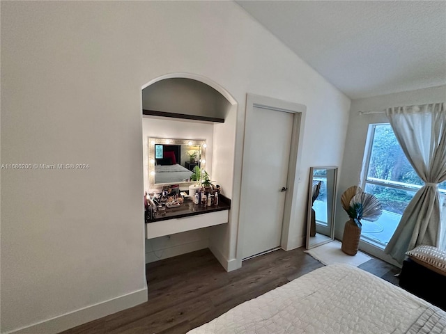 bedroom with vaulted ceiling and dark hardwood / wood-style flooring