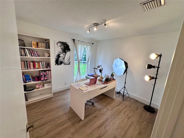 office area with a textured ceiling and hardwood / wood-style flooring