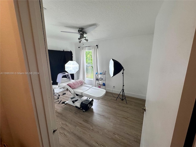 miscellaneous room featuring ceiling fan, a textured ceiling, and light wood-type flooring