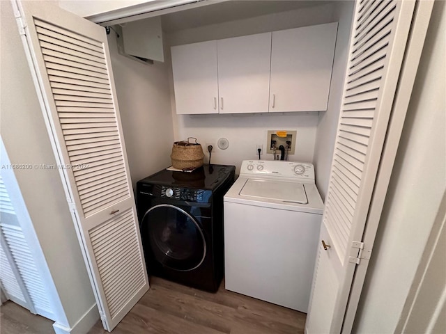 laundry area with light hardwood / wood-style flooring, washer and clothes dryer, and cabinets