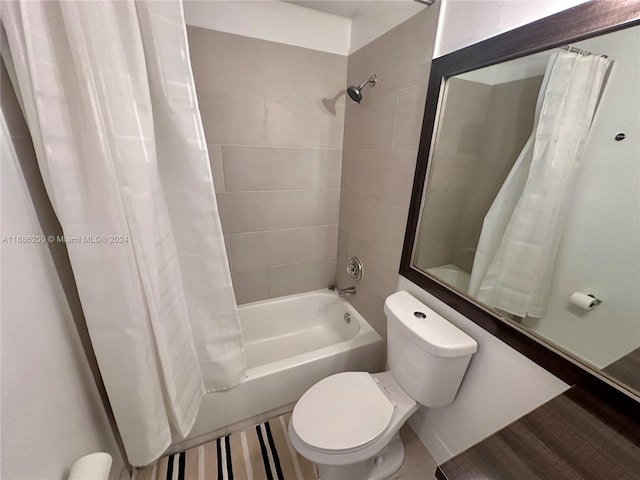 bathroom with toilet, hardwood / wood-style flooring, and shower / bathtub combination with curtain