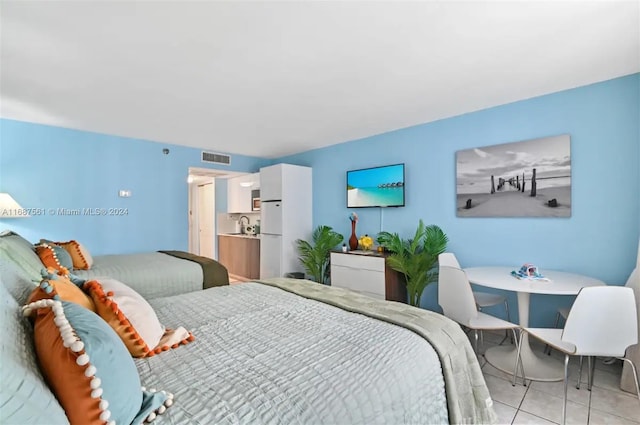 tiled bedroom featuring white refrigerator