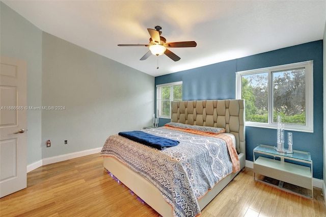 bedroom with light wood-type flooring, multiple windows, and ceiling fan