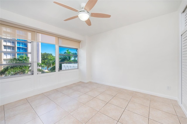 unfurnished room with ceiling fan and light tile patterned flooring