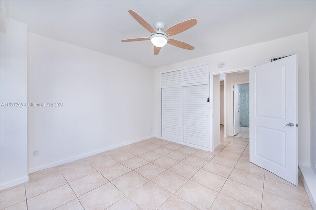 unfurnished bedroom featuring a closet, ceiling fan, and light tile patterned floors