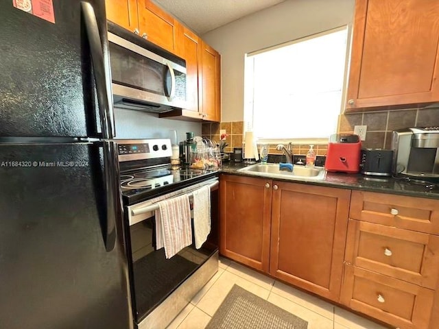 kitchen featuring backsplash, light tile patterned flooring, sink, and appliances with stainless steel finishes