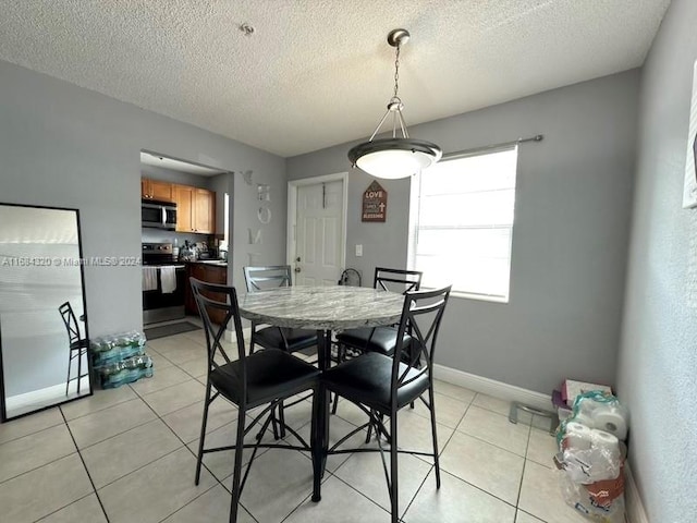 dining area with light tile patterned floors and a textured ceiling