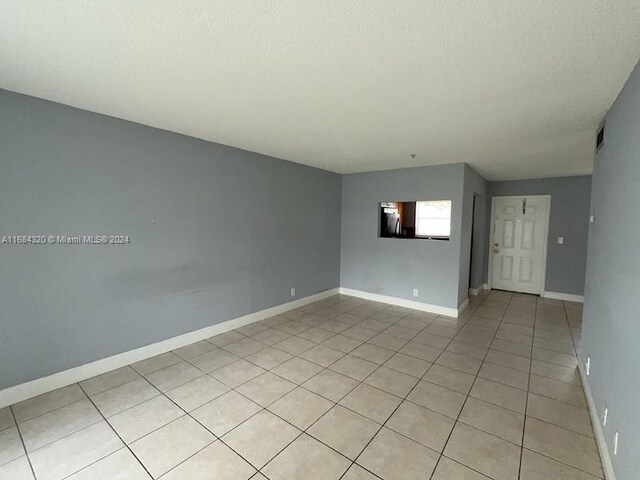 spare room with light tile patterned floors and a textured ceiling