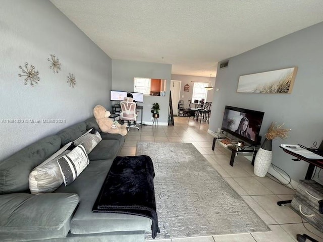 tiled living room featuring a textured ceiling