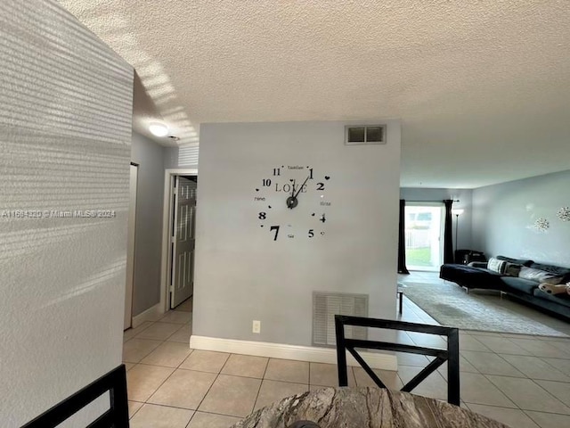 interior space featuring light tile patterned flooring and a textured ceiling