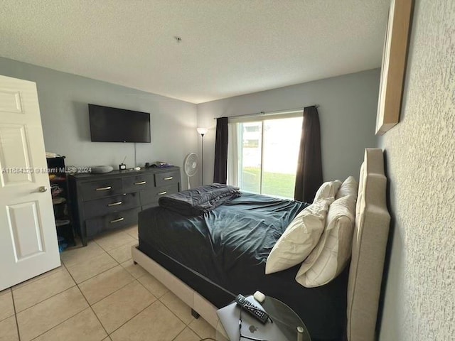 bedroom featuring light tile patterned floors and a textured ceiling