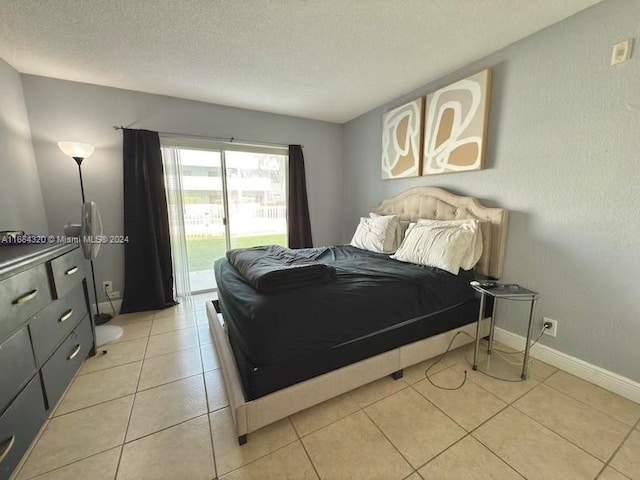 bedroom with light tile patterned floors, a textured ceiling, and access to outside