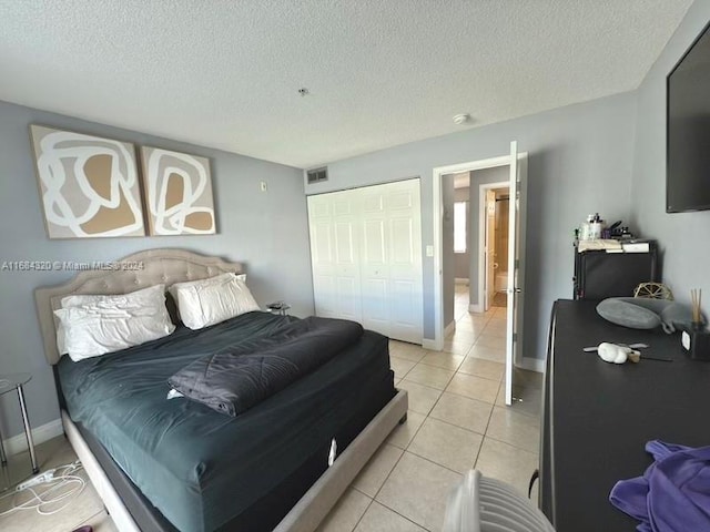 tiled bedroom featuring a textured ceiling and a closet