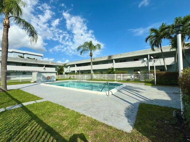 view of pool featuring a lawn and a patio area