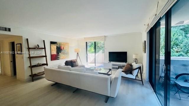 living room featuring hardwood / wood-style floors and crown molding