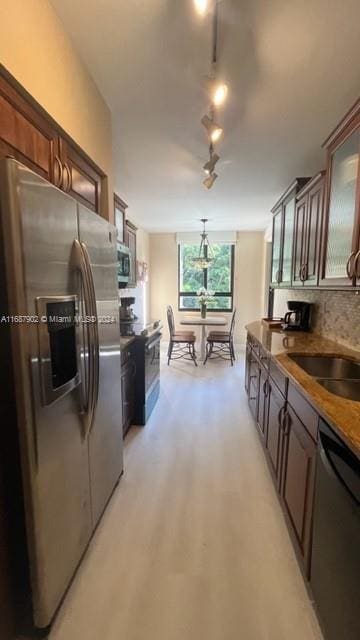 kitchen with decorative backsplash, dark brown cabinetry, stainless steel appliances, and sink