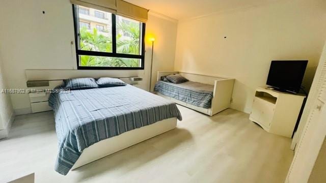 bedroom featuring light hardwood / wood-style flooring and crown molding