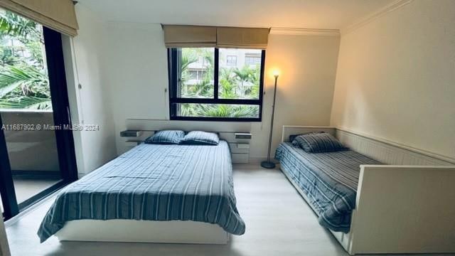 bedroom with crown molding and light wood-type flooring