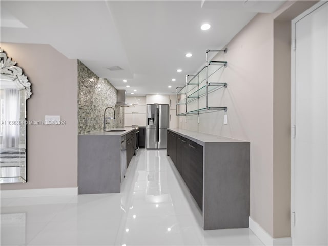 kitchen featuring stainless steel refrigerator with ice dispenser, wall chimney exhaust hood, sink, tasteful backsplash, and light tile patterned flooring