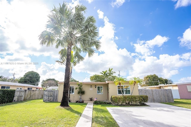 view of front of property with fence, a front lawn, and stucco siding