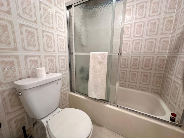 bathroom featuring tile patterned flooring, shower / bath combination with glass door, and toilet